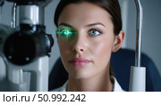 Patient undergoing eye examination with green laser light in ophthalmology clinic. Стоковое фото, фотограф Юрий Поздников / Фотобанк Лори