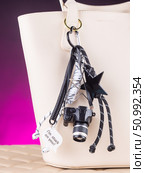 Close-up of a collection of black keychains shaped like cameras, complemented by decorative cords and beads. Стоковое фото, фотограф Виталий Сова / Фотобанк Лори