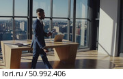 Professional businessman navigating sleek office, scrolling smartphone near expansive window, overlooking urban cityscape with confident demeanor. Стоковое AI-видео, аниматор Данил Руденко / Фотобанк Лори
