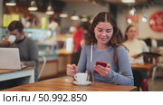 Young woman with phone in cafe. Стоковое видео, видеограф Яков Филимонов / Фотобанк Лори