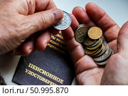 Woman's hands holding russian coins over the pension certificate. Russian translation - Ministry of Social Protection of Population of Russian Federation. Pension Certificate. Стоковое фото, фотограф Denis Vostrikov / Фотобанк Лори