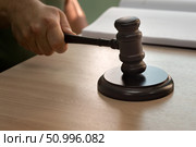Judge gavel in male hands against background of desk and notebook. selective focus. Стоковое фото, фотограф Анищенко Геннадий / Фотобанк Лори