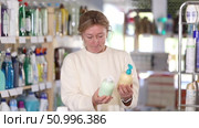 Female buyer chooses liquid hand soap in household goods department of the supermarket. Стоковое видео, видеограф Яков Филимонов / Фотобанк Лори