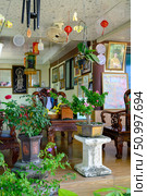 NHA TRANG, VIETNAM - APRIL 28, 2025. Study with carved wooden furniture and flowers, open to the garden, in the Buddhist Hua Da Bao Monastery. Редакционное фото, фотограф Сергей Фролов / Фотобанк Лори