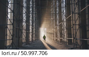Construction worker wearing safety vest and hardhat walking through scaffolding on building site at sunset, representing construction industry, engineering, and development. Стоковое AI-видео, аниматор Данил Руденко / Фотобанк Лори