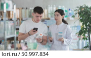 Man scans QR code on box skin cream label. Female pharmacist offers to choose the right gel. Стоковое видео, видеограф Яков Филимонов / Фотобанк Лори