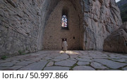 Solitary monk standing within medieval stone church, sunlight filtering through stained glass, radiating contemplative spiritual atmosphere. Стоковое AI-видео, аниматор Данил Руденко / Фотобанк Лори