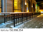 Metal ramp with wooden handrails for wheelchairs and prams along building in winter evening. Стоковое фото, фотограф Зарифа Арсланова / Фотобанк Лори