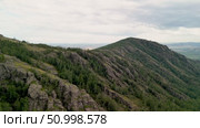 Scenic landscape featuring steep mountains and dense forests in a valley, with dramatic cloud formations above, highlighting the tranquility of the natural environment. Стоковое видео, видеограф Ирина Ручушкина / Фотобанк Лори