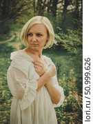 A frightened, offended young woman with a short blond haircut crossed and pressed her arms to chest in fear and looks away. Стоковое фото, фотограф Екатерина Красникова / Фотобанк Лори