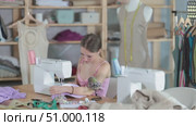 Fashion designer sews clothes on a sewing machine. Dressmaker works in the workshop. Clothing making process. Стоковое видео, видеограф Яков Филимонов / Фотобанк Лори