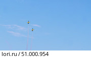 A number of military training planes execute of steep dives, followed by soaring high into sky above cityscape, as part of an aerial demonstration featuring acrobatic maneuvers. Стоковое видео, видеограф Strunov David / Фотобанк Лори