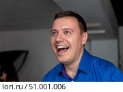 Energetic millennial handsome man wearing blue shirt standing with big smile on face, open mouth best excited feelings emotions, looking aside, listen good news. Стоковое фото, фотограф Данила Большаков / Фотобанк Лори