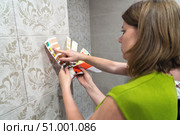 Two women choosing samples of furniture paint. Interior designer consulting client looking at color swatch. Couple with palette of colors selects harmonious color of furniture with existing tiles in bathroom. Стоковое фото, фотограф Данила Большаков / Фотобанк Лори