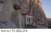 White stone house nestled against rocky cliff, featuring sale sign during golden sunset with mountainous landscape in Cappadocia, Turkey. Стоковое AI-видео, аниматор Данил Руденко / Фотобанк Лори
