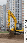 Excavator moving soil on construction site near residential buildings. Стоковое AI-видео, аниматор Юрий Поздников / Фотобанк Лори