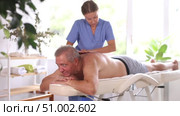 Skilled middle-aged masseuse conducting back massage therapy for man client in procedure room. Стоковое видео, видеограф Яков Филимонов / Фотобанк Лори