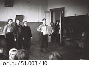 Концерт самодеятельности в деревенской школе, 1950-е годы. Три девушки поют  и молодой человек играет на баяне. Зрители. Стоковое фото, фотограф Retro / Фотобанк Лори