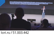 Audience observing a speaker presenting on stage in a conference setting. Стоковое видео, видеограф Антон Гвоздиков / Фотобанк Лори