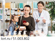 Middle-aged woman with daughter scanning barcode on pills in drugstore. Стоковое фото, фотограф Яков Филимонов / Фотобанк Лори