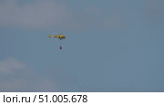 Yellow helicopter with red bambi bucket mid flight. Стоковое видео, видеограф Данил Руденко / Фотобанк Лори