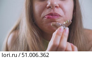 Woman eating pistachio-covered Dubai chocolate in slow motion. Стоковое видео, видеограф Mihail Mihaylov / Фотобанк Лори