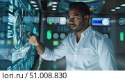 A man engages with advanced digital interfaces while analyzing data in a modern control room environment. Стоковое AI-видео, аниматор Данила Большаков / Фотобанк Лори