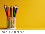 Close-Up of Vibrant Colorful Pencils in a pen holder isolated on yellow background. Banner, copy space. Colourful sharpened colored pencils for art projects, drawing, and creativity. Back to school. Стоковое AI-изображение, AI-художник Марина Демидюк / Фотобанк Лори