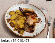 Lunch is served on plate - pieces of young rabbit baked with slice of potato. Close-up. Стоковое фото, фотограф Яков Филимонов / Фотобанк Лори