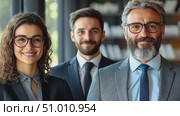 A diverse group of three professionals stands together in an office, displaying teamwork and confidence while engaging in a collaborative atmosphere. Стоковое AI-видео, аниматор Данила Большаков / Фотобанк Лори