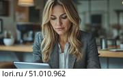 A focused woman in professional attire interacts with a tablet in a stylish office setting, highlighting her engaging work routine. Стоковое AI-видео, аниматор Данила Большаков / Фотобанк Лори