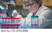 A researcher carefully prepares samples with precision in a well-equipped lab, surrounded by colorful test tubes and essential equipment. Стоковое AI-видео, аниматор Данила Большаков / Фотобанк Лори