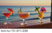 Three glass glasses with different cocktails on counter of beach bar against background of calm sea at sunset. Concept of summer vacation at resort. Slight blurred. Стоковое AI-видео, аниматор Ирина / Фотобанк Лори