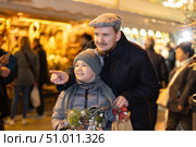 Man with son stands in middle of shopping area decorated for New Year holidays. Стоковое фото, фотограф Яков Филимонов / Фотобанк Лори
