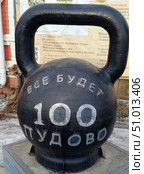 100 пудовая чугунная гиря копилка в городе Верхнеуральск Челябинская область на фоне баннера о истории вернеуральского уезда на фасаде здания краеведческого музея. Редакционное фото, фотограф Надежда Бирюкова / Фотобанк Лори