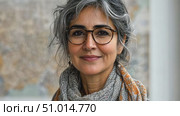 A gray-haired woman in stylish glasses and a cozy scarf radiates warmth and confidence against a vibrant map backdrop. Стоковое AI-видео, аниматор Данила Большаков / Фотобанк Лори