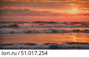 Sun slowly dip below the horizon, casting a golden glow over the rolling waves of the ocean. Стоковое AI-видео, аниматор Данила Большаков / Фотобанк Лори
