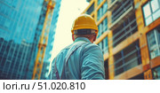 Heroic perspective of construction worker from below, yellow hard hat prominent against steel beams. Symbolizes modern infrastructure growth and skilled labor. Стоковое AI-изображение, AI-художник Светлана Леуто / Фотобанк Лори