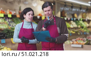 Man and woman sellers taking inventory in vegetable shop. Стоковое видео, видеограф Яков Филимонов / Фотобанк Лори
