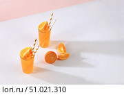 Modern still life with citrus fruits, orange juice and ingredients on a colored pink background with long hard shadows, minimal detox diet concept, summer vitamin drinks, selective focus, place for text. Стоковое фото, фотограф Светлана Балынь / Фотобанк Лори