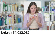 Young woman chooses nail polish in store. Стоковое видео, видеограф Яков Филимонов / Фотобанк Лори