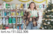Pleased young woman deciding which gift basket to buy in hygiene products shop in X-mas. Стоковое видео, видеограф Яков Филимонов / Фотобанк Лори