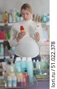 Interested expecting mother shopping in personal care store, thoughtfully selecting natural sunscreen for best protection for sensitive skin. Стоковое видео, видеограф Яков Филимонов / Фотобанк Лори
