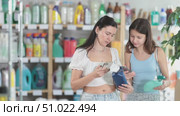 Woman with teen daughter buyer scans qr code on tile cleaner spray label. Стоковое видео, видеограф Яков Филимонов / Фотобанк Лори