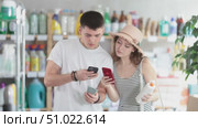 Couple buyer scans qr code on sunblock cream label. Стоковое видео, видеограф Яков Филимонов / Фотобанк Лори