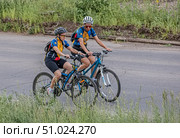 Спортсмены, велосипедисты в экипировке катаются на велосипедах по шоссе. Редакционное фото, фотограф Анатолий Володин / Фотобанк Лори