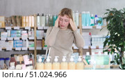 Young female client having severe headache while being in chemist's shop. Стоковое видео, видеограф Яков Филимонов / Фотобанк Лори