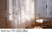 Bright sunlit room with delicate curtains and an elegant chair in a peaceful setting. Стоковое AI-изображение, AI-художник Сергей Толмачёв / Фотобанк Лори