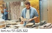 Young man choosing carpet samples in store. Стоковое видео, видеограф Яков Филимонов / Фотобанк Лори