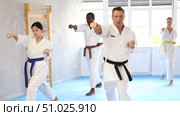 Multinational students repeat position and perform sequence of punches and painful techniques kata. Стоковое видео, видеограф Яков Филимонов / Фотобанк Лори